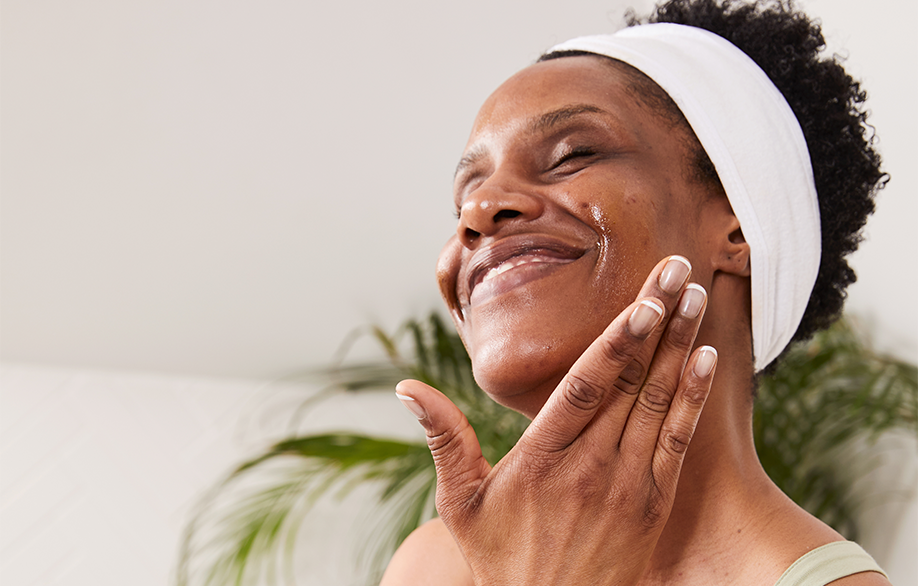 Woman applies Super Greens to skin and is gently patting the product into her skin.